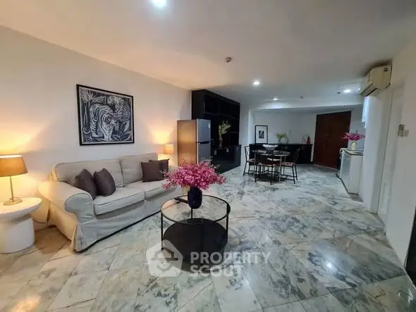 Spacious open-plan living room with modern decor and marble flooring