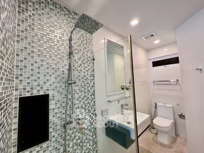 Modern bathroom with mosaic tiles and glass shower enclosure