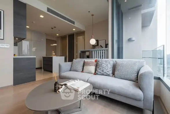 Modern living room with stylish decor and large windows offering city views.