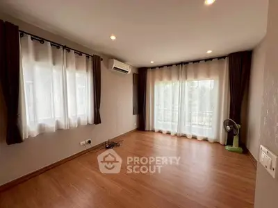 Spacious empty living room with large windows and wooden flooring