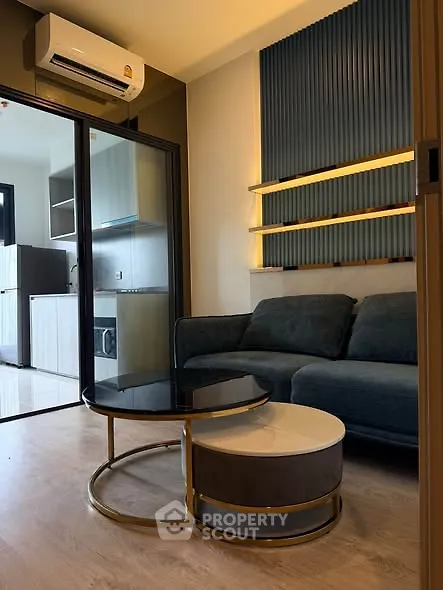 Modern living room with stylish furniture and open kitchen layout in a cozy apartment.