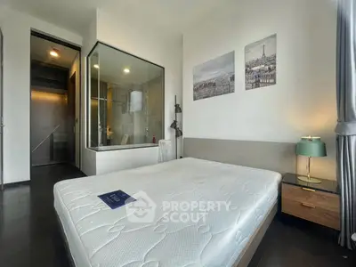 Modern bedroom with glass-walled ensuite bathroom and stylish decor