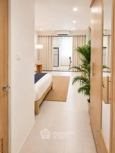 Spacious bedroom with modern decor and natural light, featuring a cozy bed and stylish furnishings.