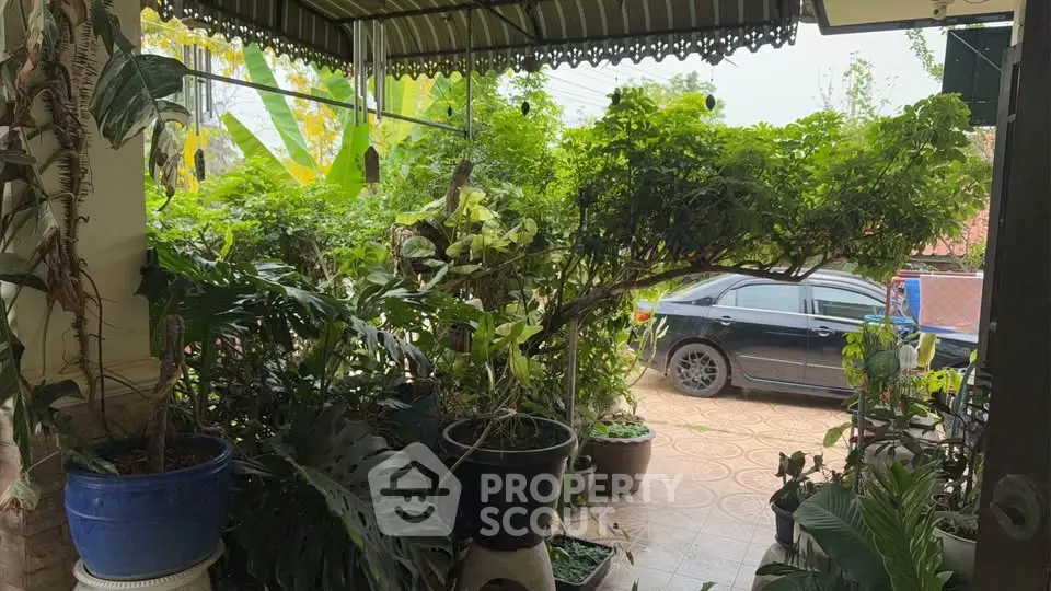 Charming garden patio with lush greenery and car parking space, perfect for nature lovers.