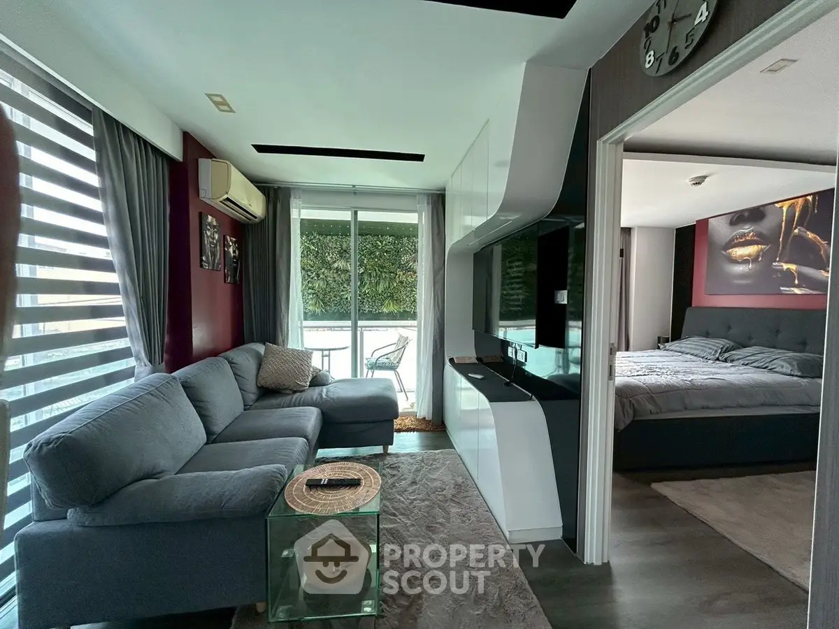 Modern living room with sleek design and cozy bedroom view, featuring stylish furniture and natural light.