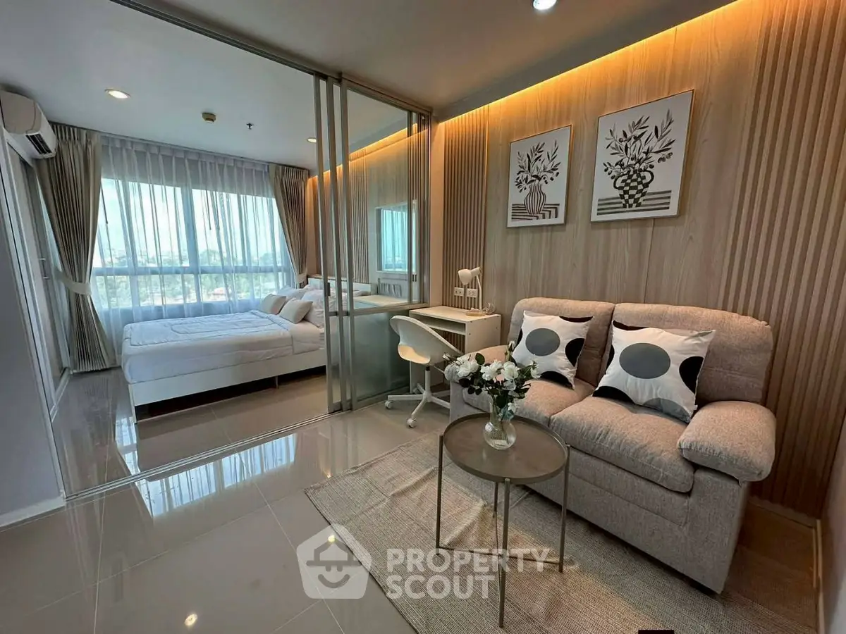 Modern studio apartment with glass partition, cozy living area, and stylish decor.