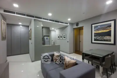 Modern living room with sleek furniture and open kitchen layout in a stylish apartment.