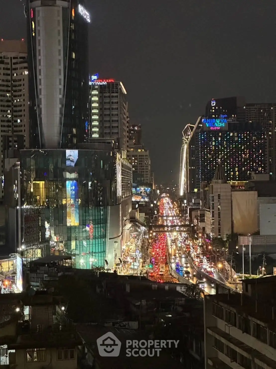 Stunning nighttime cityscape view with illuminated skyscrapers and bustling street traffic