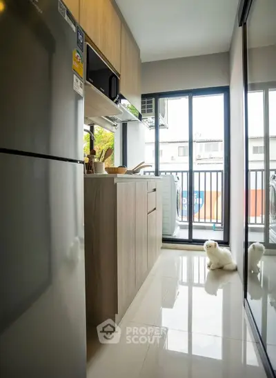 Modern kitchen with sleek appliances and large window overlooking balcony