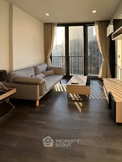 Modern living room with sleek furniture and large windows offering natural light.