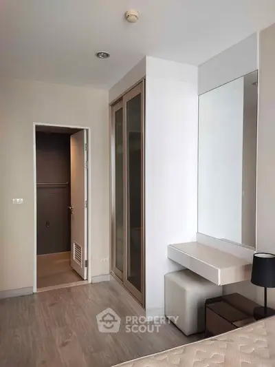 Modern bedroom with built-in closet and vanity, featuring sleek design and neutral tones.