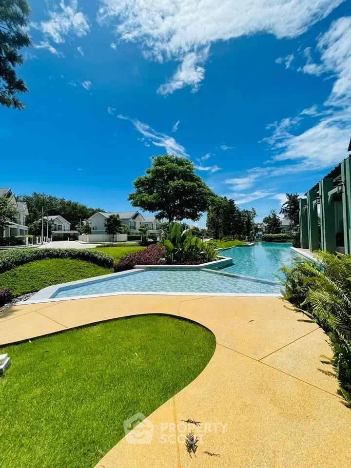 Luxurious outdoor pool area with lush greenery and clear blue sky