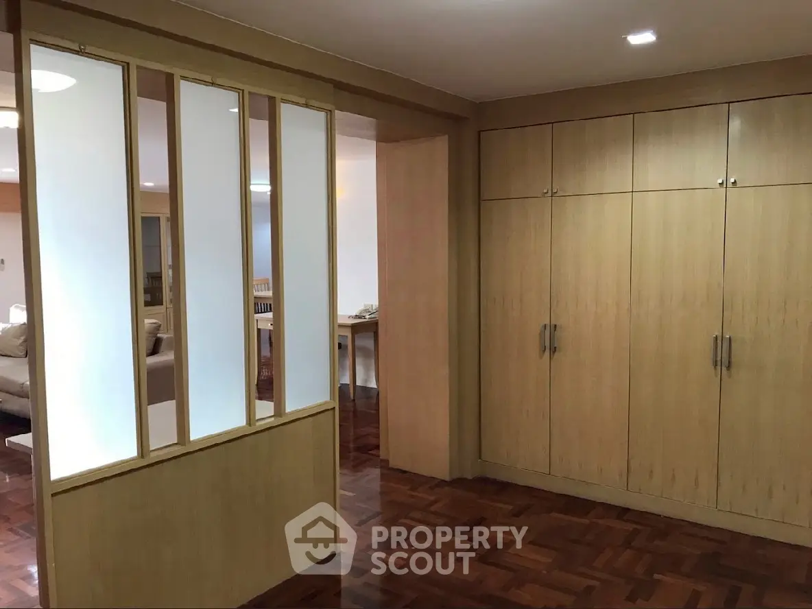 Spacious interior with wooden flooring and built-in storage cabinets