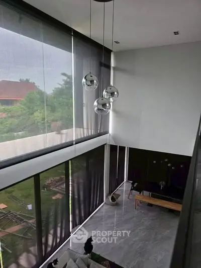 Stunning modern living room with high ceilings and large windows offering a serene garden view.