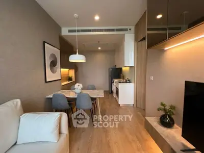 Modern living room with dining area and sleek kitchen in open layout apartment.