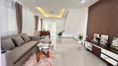 Modern living room with stylish decor and open layout, featuring a cozy sofa and elegant lighting.