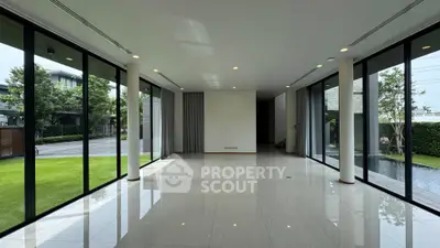 Spacious modern living room with floor-to-ceiling windows and garden view.