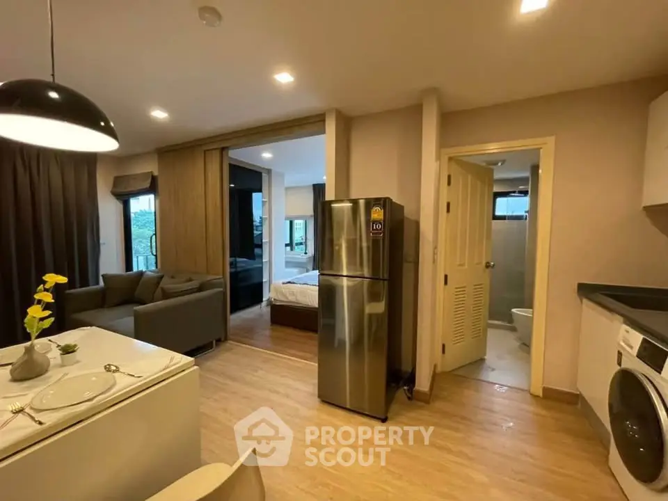 Modern open-plan apartment with kitchen, living area, and bedroom view.