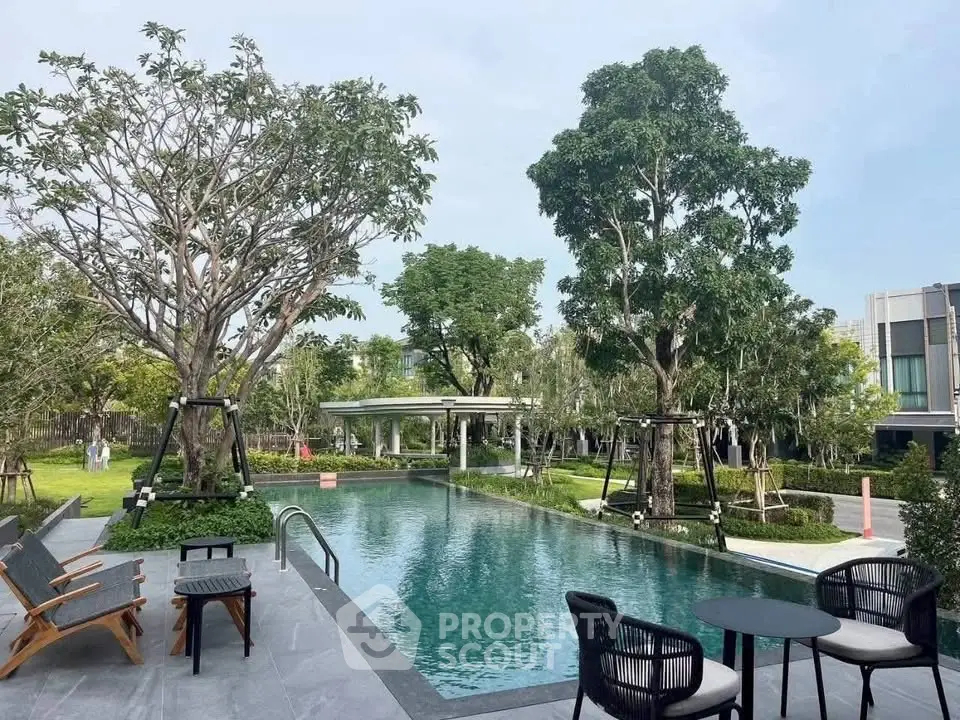 Luxurious outdoor pool area with lush greenery and modern seating, perfect for relaxation and leisure.