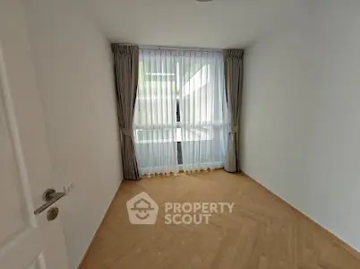 Bright empty room with large window and elegant curtains, perfect for customization.