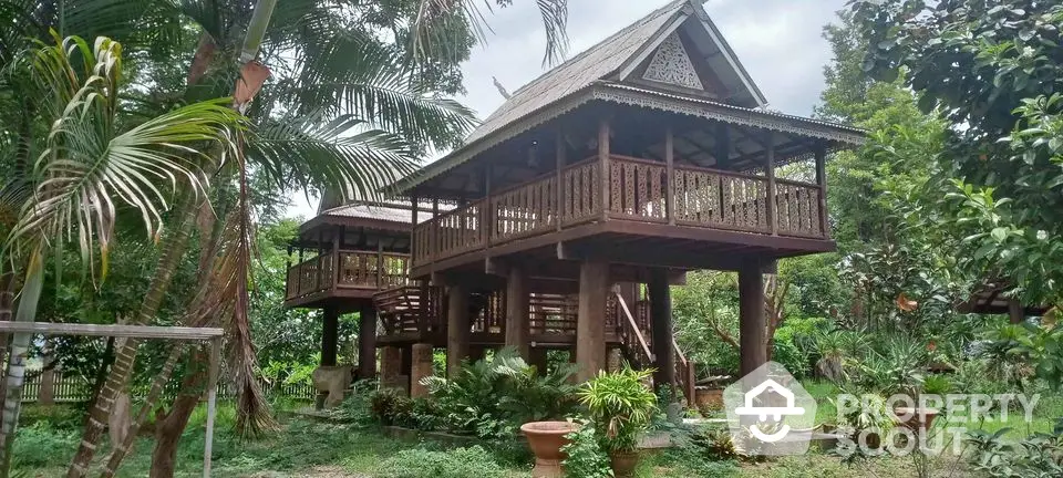 Charming traditional wooden stilt house surrounded by lush greenery, offering a serene and rustic living experience.