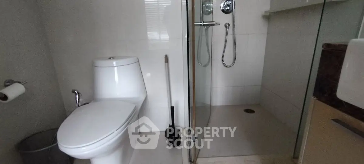 Modern bathroom with glass shower and sleek fixtures in a contemporary home.