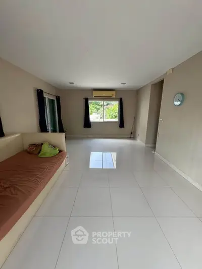 Spacious living room with large windows and minimalist decor, perfect for modern living.