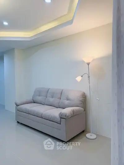 Modern living room with cozy gray sofa and stylish floor lamp
