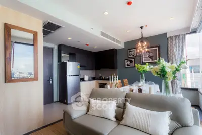 Modern living room with open kitchen, elegant decor, and city view.