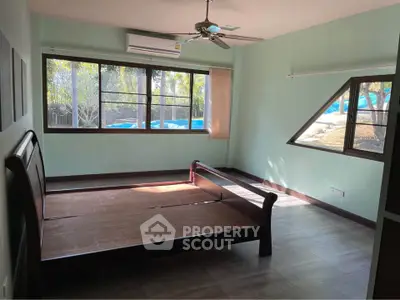 Spacious bedroom with large windows and wooden bed frame