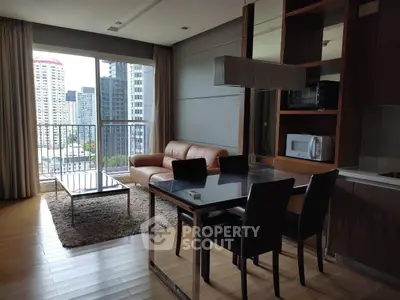Modern living room with city view, leather sofa, dining area, and sleek kitchen appliances.