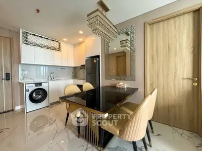 Modern kitchen with dining area, featuring sleek appliances and elegant decor.