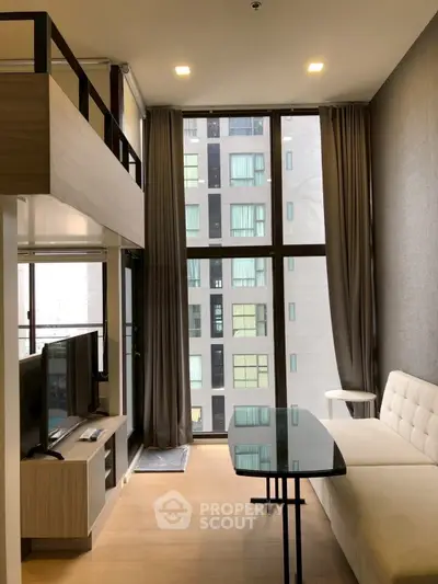 Modern loft-style living room with floor-to-ceiling windows and stylish furniture