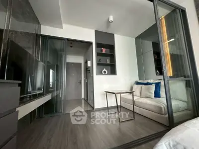 Modern living room with sleek design and glass partition, featuring cozy seating and stylish decor.