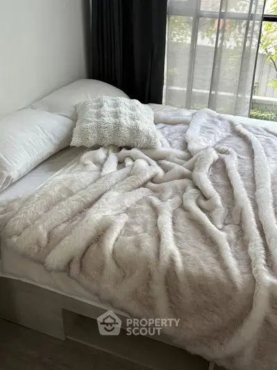 Cozy bedroom with plush bedding and large window view