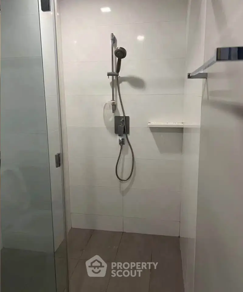 Modern bathroom shower area with sleek design and glass door enclosure.