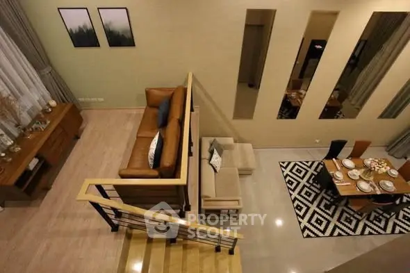 Spacious modern living room with stylish decor and dining area, featuring a cozy seating arrangement and elegant staircase.