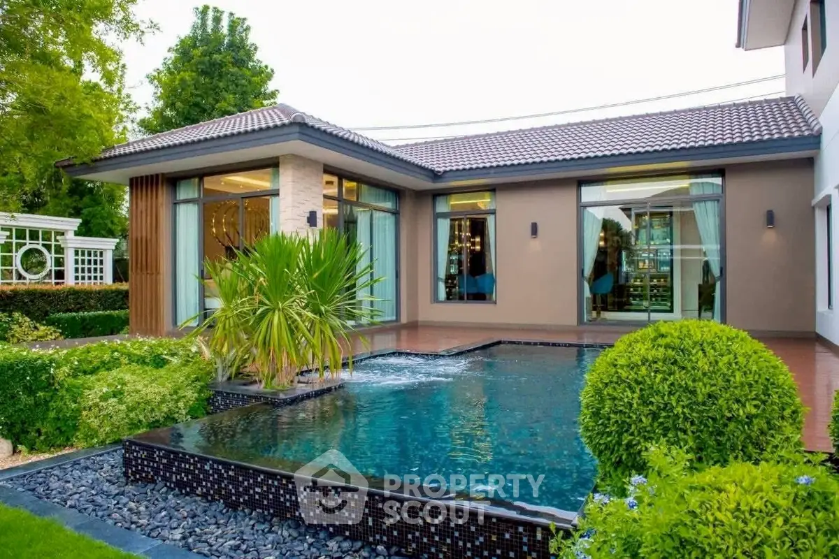 Luxurious modern home with stunning pool and lush garden landscape.