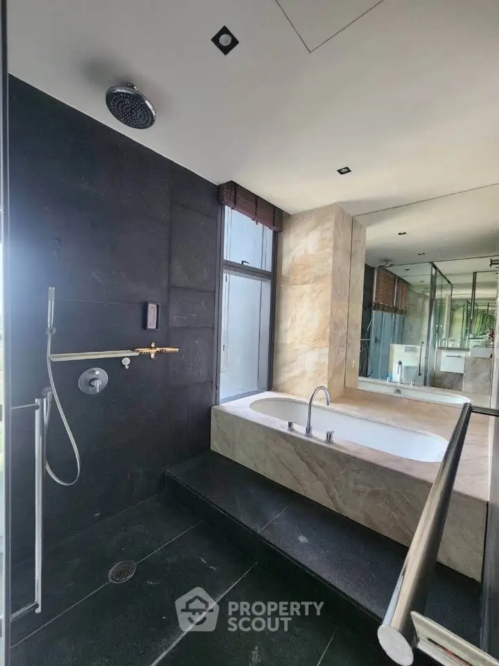 Luxurious modern bathroom with sleek black tiles and elegant bathtub