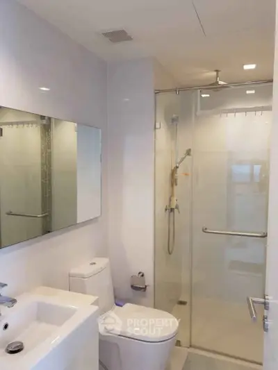 Modern bathroom with glass shower and sleek fixtures in a contemporary home.