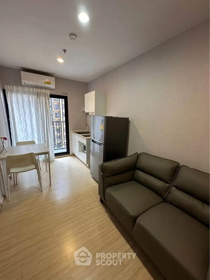 Modern apartment interior with cozy living room and kitchen, featuring sleek furniture and natural light.