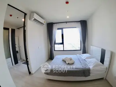 Modern bedroom with large window and air conditioning in a stylish apartment.