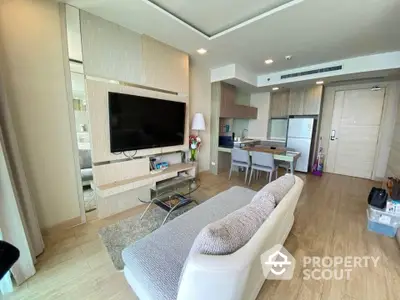 Modern living room with open kitchen, stylish decor, and cozy seating area in a contemporary apartment.