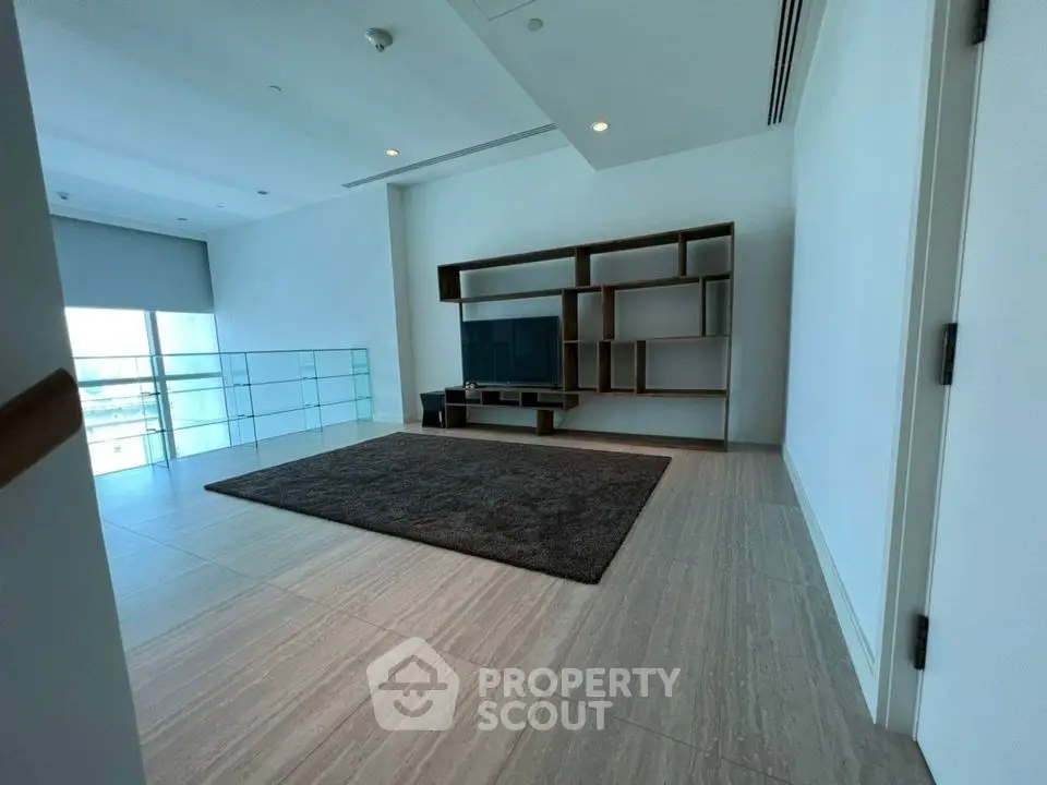 Spacious modern living room with sleek shelving and large windows offering natural light.