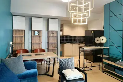 Modern open-layout living room with stylish kitchen and unique lighting fixtures.
