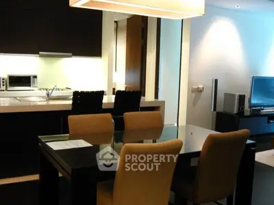 Modern open-layout kitchen and dining area with sleek furniture and ambient lighting.