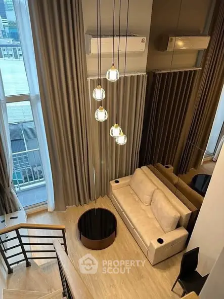 Modern loft apartment with high ceilings, stylish lighting, and large windows offering city views.
