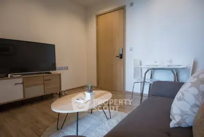 Modern living room with stylish furniture and flat-screen TV, perfect for cozy relaxation.