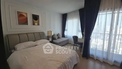 Modern bedroom with large windows and stylish decor in a high-rise apartment.