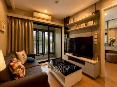 Cozy living room with modern decor and large TV, featuring a balcony view.